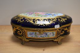 A hand painted Limoge casket, sat on four cast metal feet, having cobslt blue ground with floral