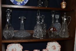 Seven decanters, including cut glass decanter with plated handle, and other examples of various