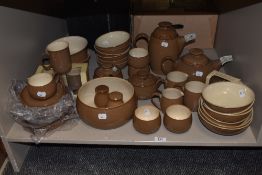 A large collection of Denby stoneware in fawn brown glaze, including plates in original packaging,