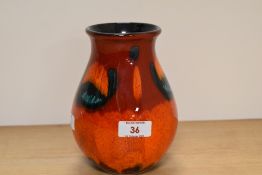 A Poole pottery vase, having orange, red and green lava like glaze.