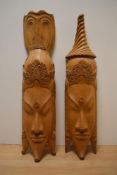 Two light wood Indonesian wall mounted masks.