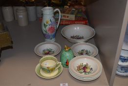 A Clarice cliff cup and saucer with floral design, a Grays pottery fruit set with fruit design to