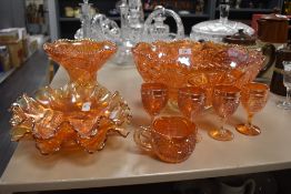 A collection of iridescent orange carnival glass, comprising; large punch bowl, four goblets,