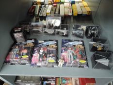 A shelf of modern Star Trek and Star Wars figures and accessories, all boxed or on bubble cards (