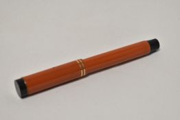 A Parker Duofold Lucky Curve Snr button fill fountain pen in red with two narrow bands to the cap