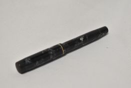 A Mentmore Auto-Flow button fill fountain pen in black and grey marble with single narrow band to