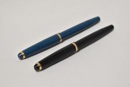 Two Onoto the Pen by De La Rue piston fill fountain pens one in black the other blue with a single