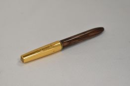 A Platignum lever fill fountain pen in brown and cream with gold coloured cap having Platignum 1st