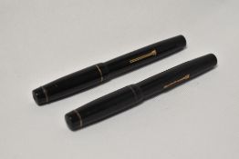 Two Croxley lever fill fountain pens in black with single narrow band to the cap, one having