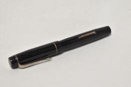 A Unique lever fill fountain pen in black with single narrow bands to the cap having Unique 14k