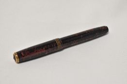 A Parker Vacumatic button fill fountain pen in burgundy with three narrow bands to the cap having