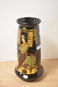 A 20th century brown moulded vase, having depiction of traditionally dressed gent leaning against