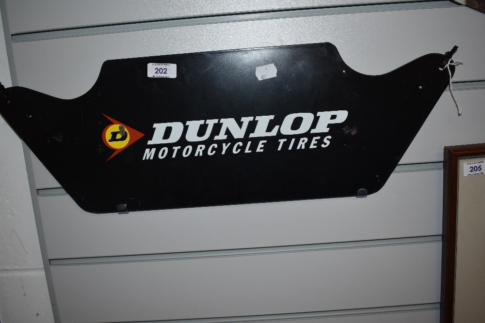 Two metal Dunlop motorcycle tires advertising signs.