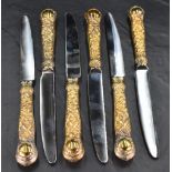 A set of six Queen Elizabeth II silver gilt handled table knives, having stainless steel blades,