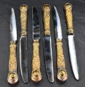 A set of six Queen Elizabeth II silver gilt handled table knives, having stainless steel blades,