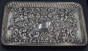 An Edwardian silver tray, of slightly dished rectangular form with gadrooned rim and fluted booge