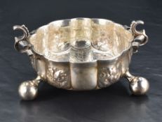 An Edwardian silver bowl, of lobed circular form with scroll-ornamented S-scrolled handles and