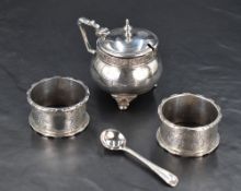 A George V silver mustard pot, of lidded and compressed spherical form with band of foliate