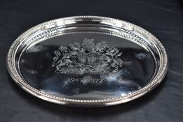 A Queen Elizabeth II silver salver, of circular form with bead-0moulded rim, produced to commemorate