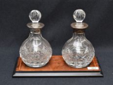 A pair of Queen Elizabeth II silver-mounted cut-crystal decanters, the globular bodies with cut with