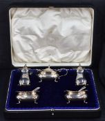A George V cased silver condiment set, comprising salts, pepperettes and mustard and three condiment