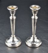 A matched pair of Queen Elizabeth II silver candlesticks, of classical design with simple bead