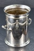 An early 20th century silver-plated bottle holder, of cylindrical form with twin handles, shallow