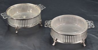 A pair of George V silver and frosted glass table salts, of circular form with pierced strapwork