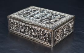 A Burmese white metal and brass box, of hinged rectangular form, decorated with panels of
