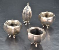A group of three George V silver condiments, of fluted and tapering cylindrical form finishing