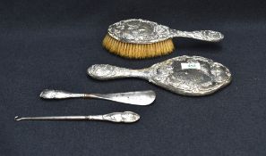 An Edwardian silver-mounted four-piece 'Dream of Love' dressing table set, comprising a hand mirror,
