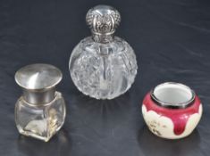 A late Victorian silver toppped cut glass scent bottle, the screw-off cover embossed with foliate