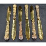 A set of six Queen Elizabeth II silver gilt dessert knives, having shaped blades, cast fruiting vine