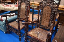 A pair of reproduction throne style chairs having canework seats and backs , with mythical