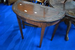 A stained frame composite demi lune hall table having carved top and square tapered legs