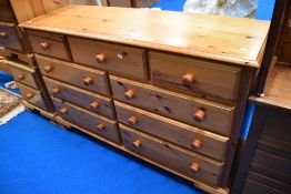 A modern pine multi drawer bedroom chest, width approx. 143cm