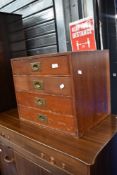 A small chest of four campaign style drawers