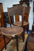 A pair of vintage bentwood chairs having decorative seat and back