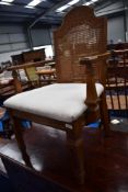 A reproduction carver chair having cane back and upholstered seat
