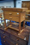 An Arts and Crafts golden oak fold over occasional table with two frieze drawers, width approx.