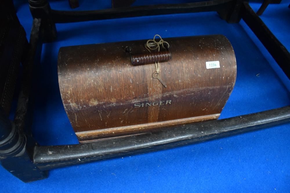 A vintage Singer sewing machine in wooden dome top case