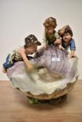 An early 20th century studio pottery centre piece, depicting three curious boys peering into a large