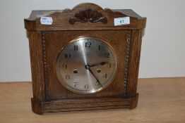 An early 20th century oak cased mantel clock, having beading and carved decoration.