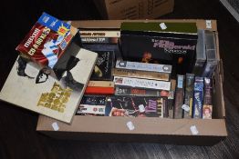 A box of video tapes, including Phil Collins, and a Buddy Holly cassette set