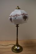 An Art Nouveau brass table lamp, the glass shade decorted with floral swags, and measuring 47cm