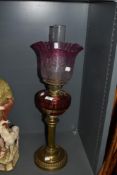 A Victorian oil lamp, having cranberry glass reservoir and etched cranberry tinged fluted shade.