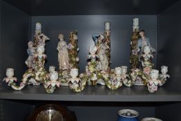 A collection of continental Sitzendorf candlesticks, some with figural displays and floral