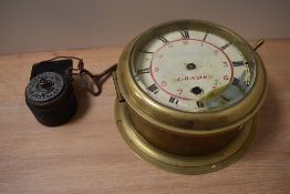 An antique brass ships Bolkhead clock, having bevelled glass door and roman numerals to face,'SS