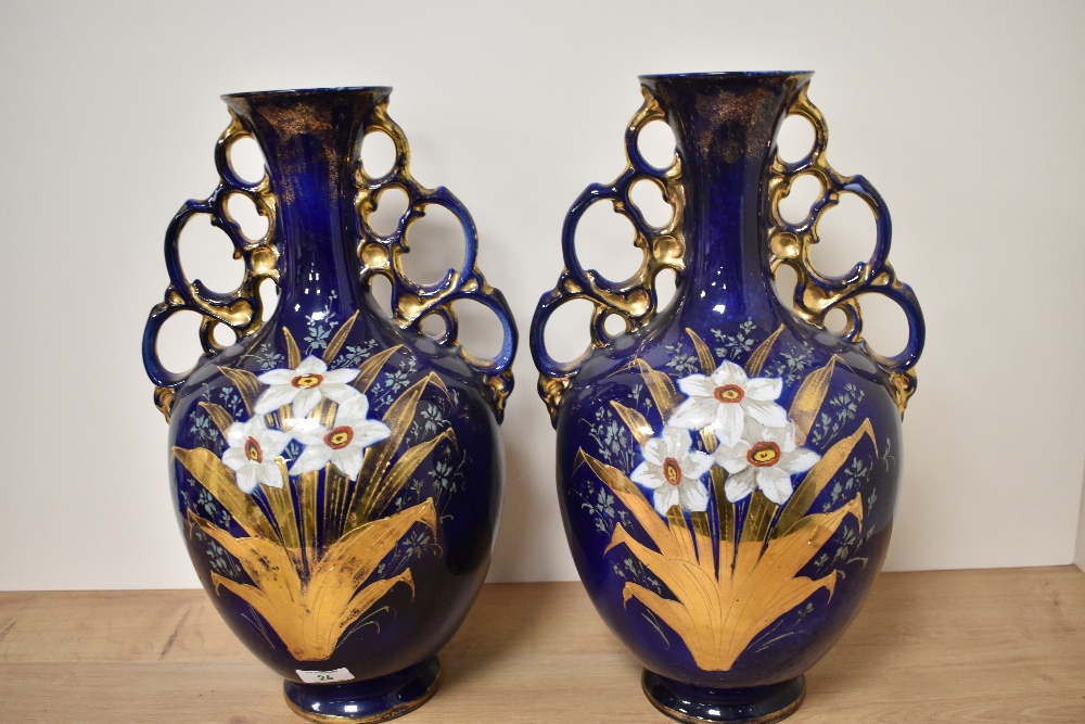 A pair of Edwardian baluster form vases with elongated neck and ornate handles to sides, having
