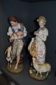 Two German bisque porcelain figurines, one depicting boy with goats and the other a girl with